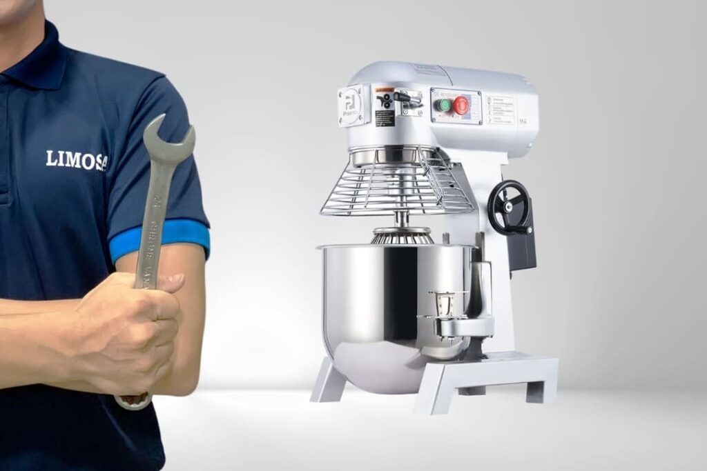 a man holding a wrench next to a mixer