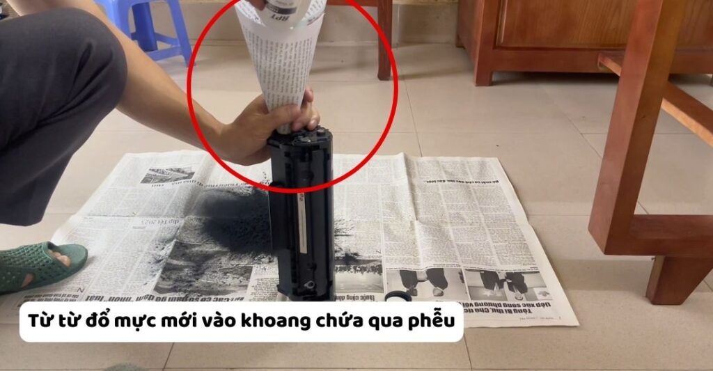 Từ từ đổ mực mới vào khoang chứa qua phễu