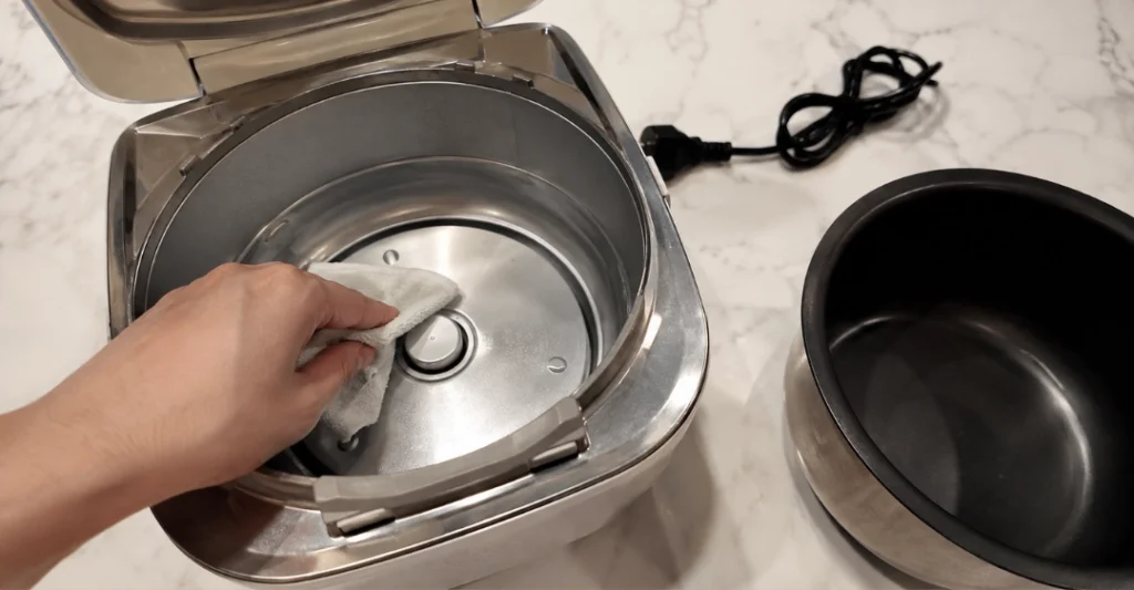 Dùng khăn mềm lau sạch cảm biến nhiệt độ dưới đáy nồi sau khi đã ngắt nguồn điện