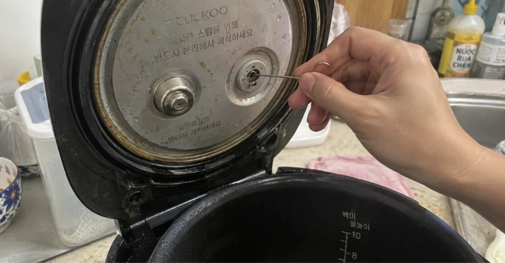 Người dùng lấy kim vệ sinh đi kèm nồi để thông đúng lỗ van